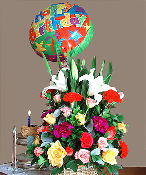 Basket of Cheers - This arrangement includes Casablanca lilies, red and fuschia carnations, and all colorful roses, with a Big 14 inch balloon with the words 